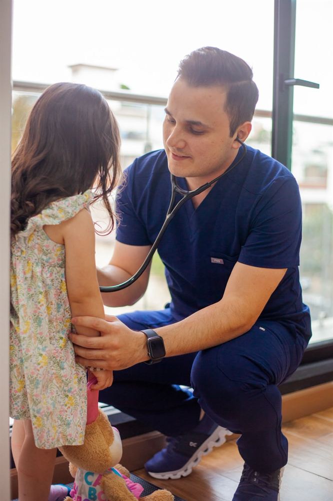 El Dr. Horacio Bartlett ausculta a una niña con el estetoscopio