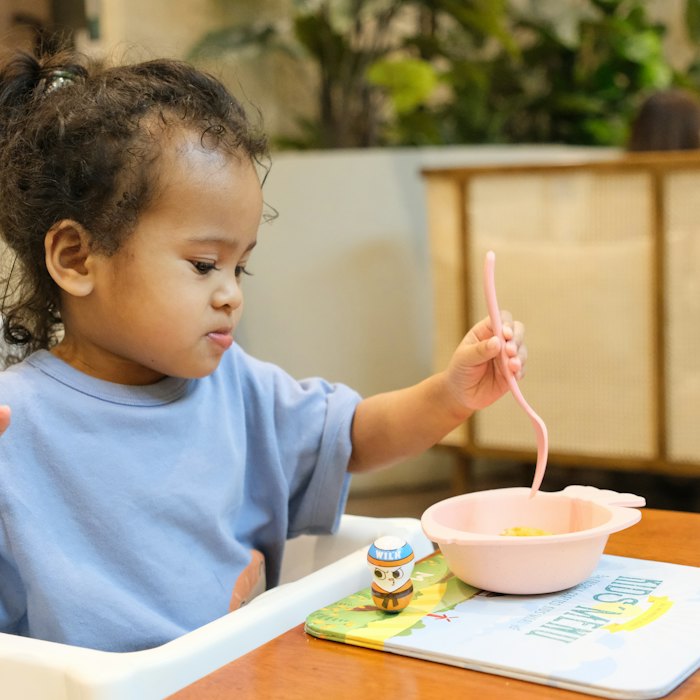 Niño pequeño comiendo con cuchara